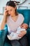 Stressed Mother Holding Crying Baby Suffering From Post Natal De