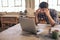 Stressed out woodworker using a laptop in his carpentry studio