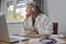 Stressed And Overworked Mature Female Doctor Wearing White Coat At Desk In Doctors Office