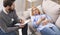 Stressed patient on sofa talking to psychologist at consultation