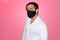 Stressed Persian businessman with mask against pink wall