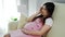 Stressed pregnant woman has a headache on sofa in living room
