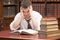 Stressed student with a pile of books to read