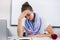 Stressed teacher suffering from headache in classroom