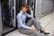 Stressed technician sitting on floor beside open server