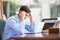 Stressed Teenage Boy Using Laptop On Desk At Home