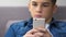 Stressed teenager playing fast video game on smartphone, school anger management