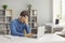 Stressed, tired, exhausted man who has burnout sitting at office desk with laptop