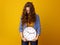 Stressed trendy woman against yellow background with clock