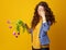 Stressed woman against yellow background with wilted flowers