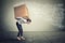 Stressed woman carrying on her back large box