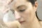 Stressed woman leaning on weeping glass shower door