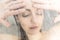 Stressed woman leaning on weeping glass shower door