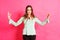 Stressed woman relaxes raising fingers with relief face, isolated on pink studio background