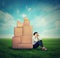 Stressed woman sitting on the ground green grass with many boxes