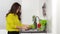 Stressed woman washing vegetables in the sink in the kitchen at home