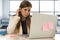 Stressed woman working with laptop computer on desk in overworked