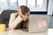 Stressed woman working with laptop computer on desk in overworked