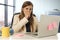 Stressed woman working with laptop computer on desk in overworked