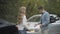 Stressed young man and woman arguing on roadside with broken cars standing at background. Caucasian drivers in road