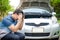 Stressful Asian men raise their hands to hold their heads The car engine crashed while traveling