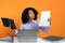 Stressful deadline. Emotional woman checking document at white table against orange background