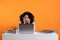 Stressful deadline. Tired woman looking at laptop at white table on orange background