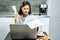 Stressful young woman holding paper in hands in the kitchen