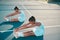 We stretch so we can be our best out there. Full length shot of two young women sitting on a tennis court together and