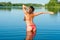 Stretching girl in bikini into lake