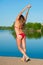 Stretching girl in bikini on lake background