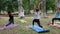 Stretching raising his hands up, female and guys on colorful mat do fitness, womens and mens doing exercises, warm-up in