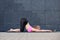 Stretching woman. fitness or gymnast or dancer doing exercises on gray wall uban background