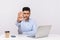 Strict bossy elegant young businessman sitting in office workplace with laptop and coffee, warning with stop gesture