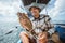 strike grouper held by an Asian angler on fishing boat