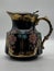 Striking black and gold teapot adorned with intricate floral decorations