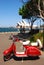 Striking classic red white Vespa motor with trees parked in front of Sydney Opera House harbour, New South Wales NSW, Australia 