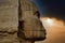 A striking close-up of the great sphinx of Giza (Cairo, Egypt) shrouded in the sunset of the desert