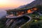 A striking, contemporary house with a green roof, perched on a mountain peak. The first light of day highlights the Easter-themed