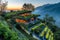 A striking, contemporary house with a green roof, perched on a mountain peak. The first light of day highlights the Easter-themed