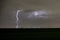 Striking nature image of a lightning bolt jumping out of the storm cloud