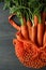 String bag with carrot on dark wooden background