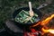 String beans in a pan. Cooking vegetables on an open fire. Food on a camping trip.