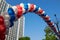 String of colorful balloons against apartment buildings and blue sky on background. Concept of outdoor celebration activities or e