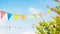 string of colorful pennant against blue sky in the garden