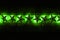 A string of green star christams lights on a dark wooden background