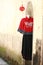 A string of lanterns and a Chinese traditional dress hang on an ancient wall