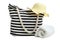 Striped beach bag with white bath towel and straw women`s hat