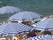 Striped beach umbrellas and white sunbeds