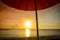 Striped beachchairs and sunshade at sunset